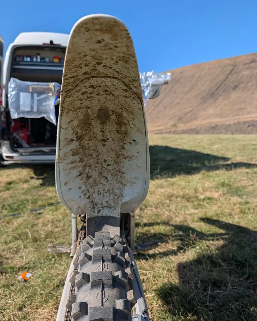 Mud-covered white motocross rear mudguard before cleaning